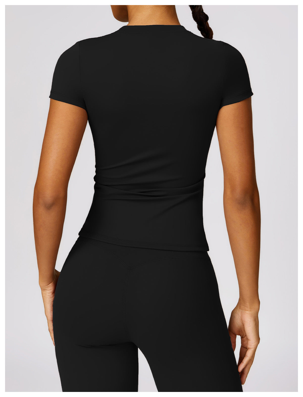 Person wearing a black athletic outfit on a light gray background